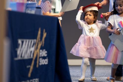 A child wears a graduation cap